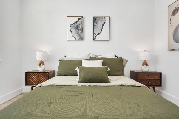 a bed room with a bed and painting on the wall