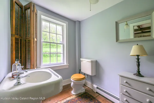a bathroom with a toilet sink and mirror