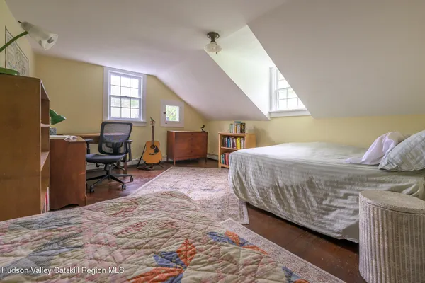 a bedroom with a bed a window and dresser