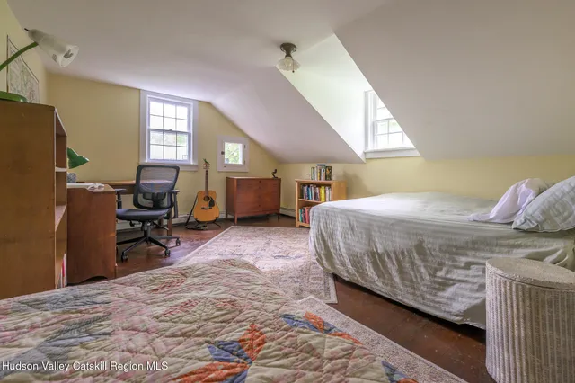 a bedroom with a bed a window and dresser