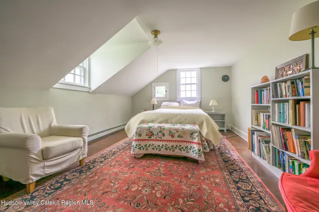 a spacious bedroom with a bed a couch and a book shelf
