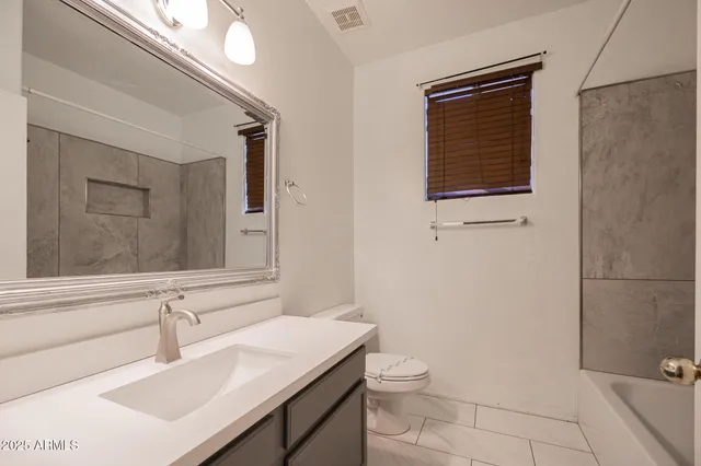 a bathroom with a sink a toilet and mirror