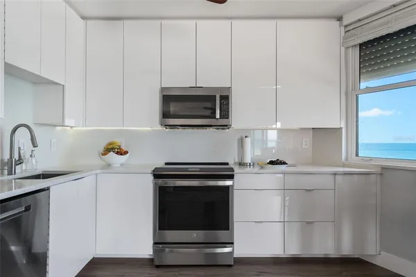 a kitchen with stainless steel appliances a refrigerator sink and microwave