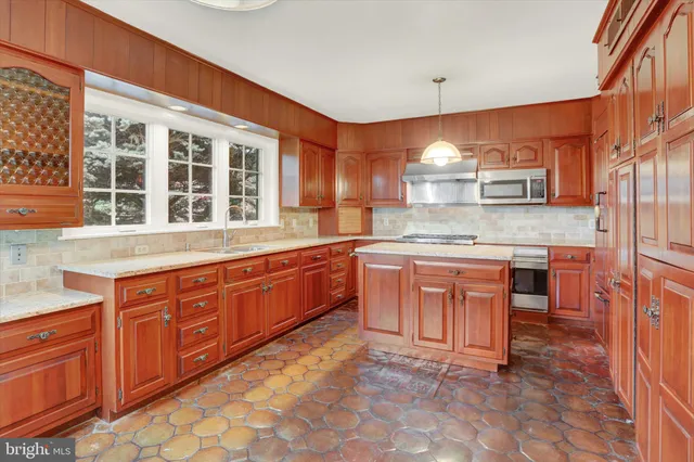 a kitchen with stainless steel appliances granite countertop a stove a sink and a refrigerator