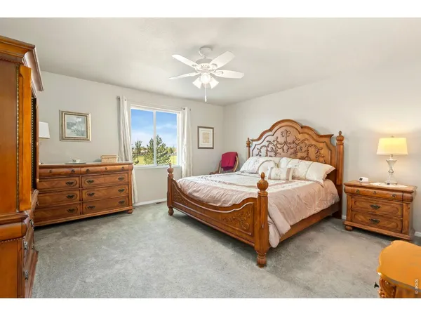 a bedroom with a bed and dresser with rug