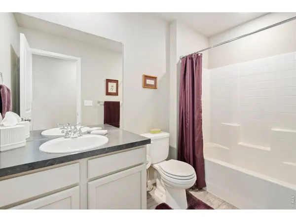 a bathroom with a granite countertop sink toilet a mirror and shower