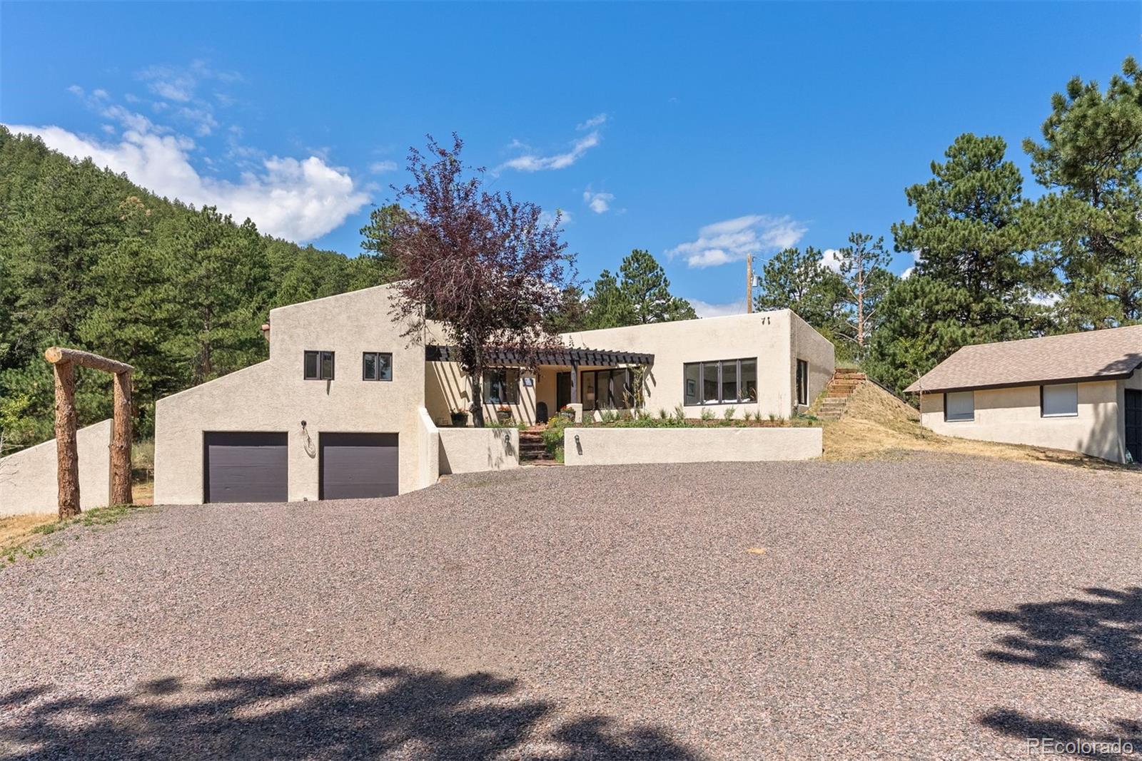 1053 Red Moon Road Evergreen, CO 80439 - Photo 22 of 50 a front view of a house with a yard and garage