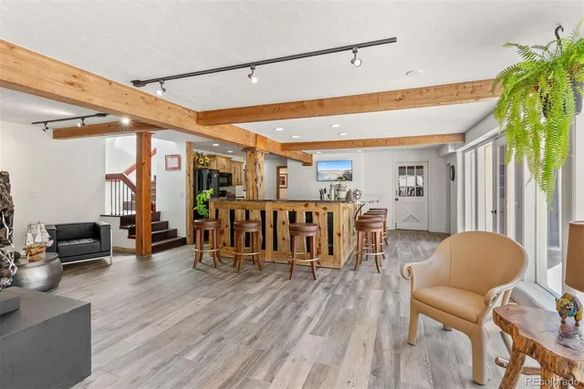 a dining hall with stainless steel appliances granite countertop a stove a sink a dining table and chairs with wooden floor