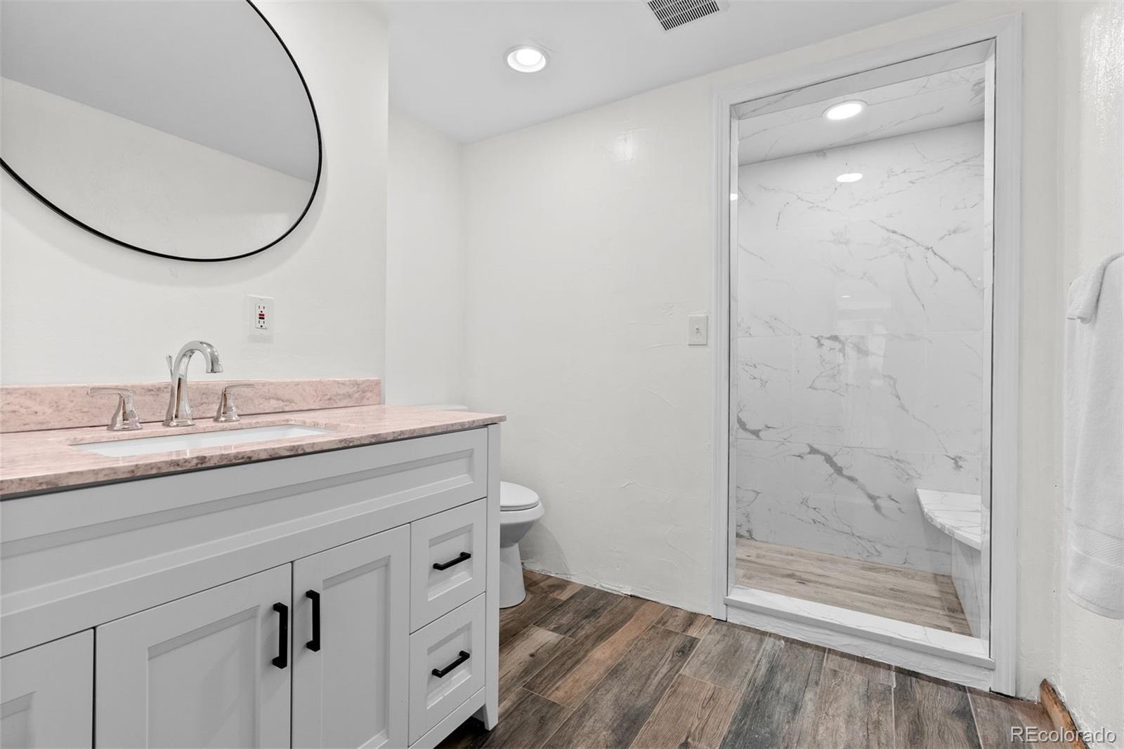 1053 Red Moon Road Evergreen, CO 80439 - Photo 33 of 50 a bathroom with a granite countertop sink a mirror and shower