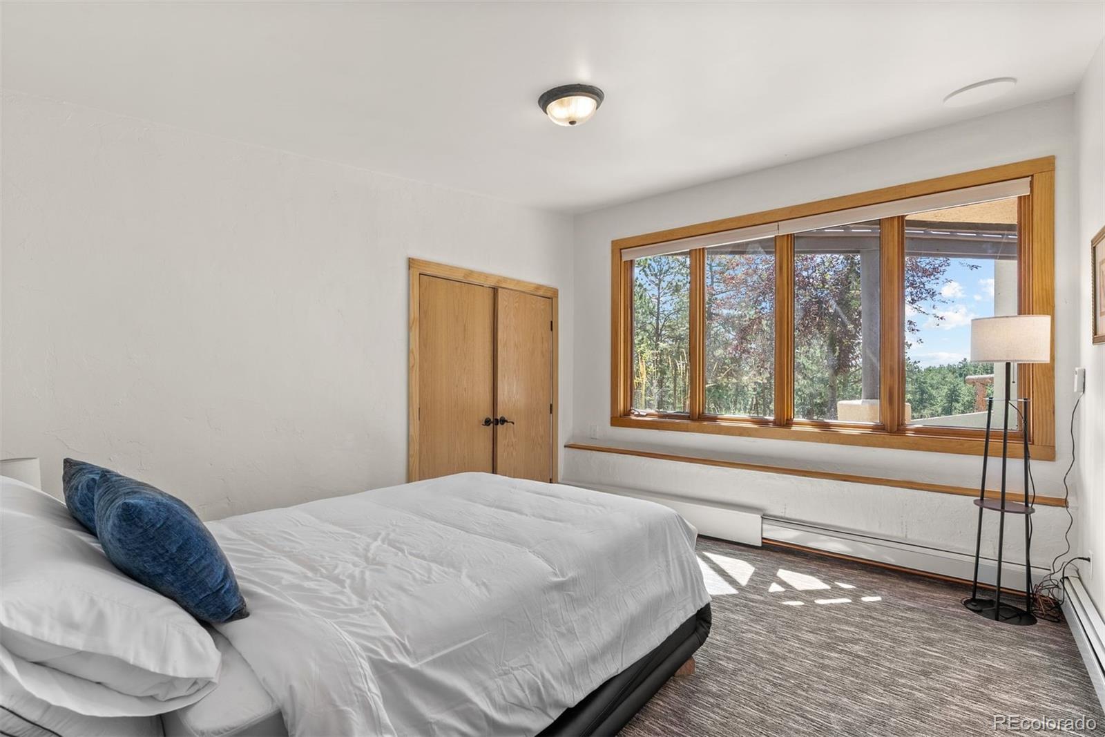 1053 Red Moon Road Evergreen, CO 80439 - Photo 44 of 50 a bedroom with a bed and a large window