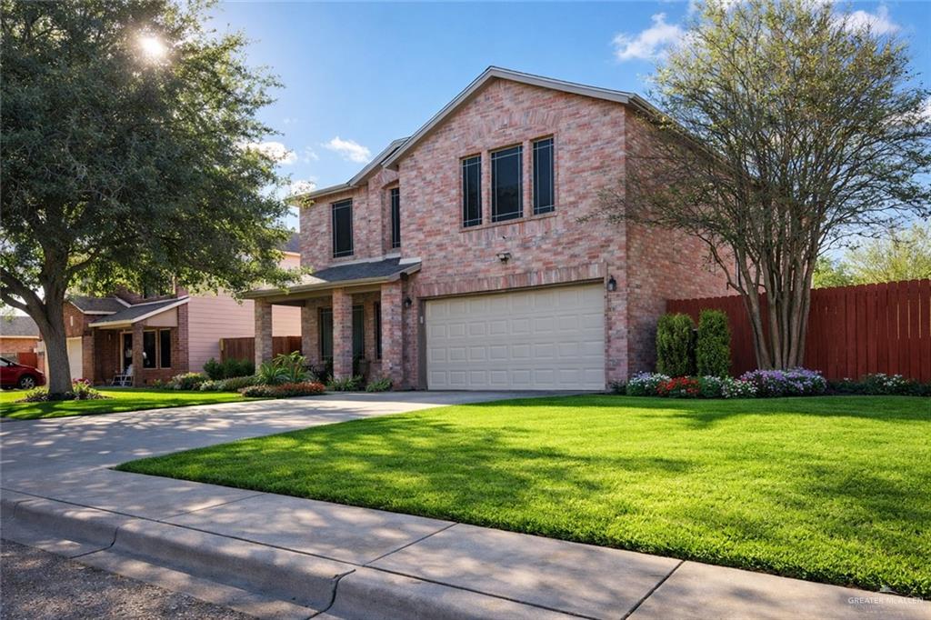 a front view of a house with a yard and trees