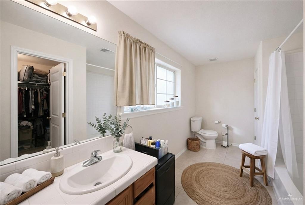 906 East Solar Drive Mission, TX 78574 - Photo 14 of 18 a bathroom with a granite countertop sink a toilet and a mirror