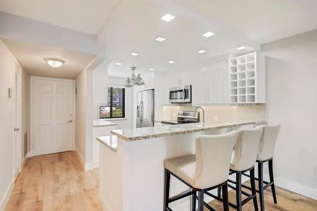 a kitchen with stainless steel appliances kitchen island granite countertop a sink and cabinets