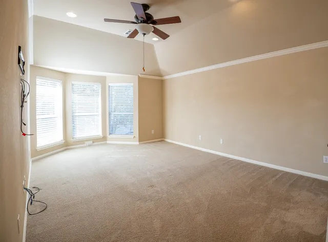 an empty room with windows and fan