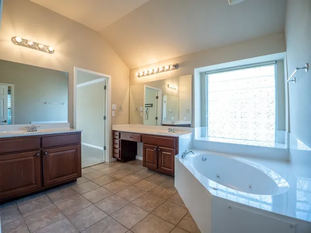 a large bathroom with a large tub and double vanity