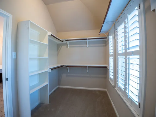 a view of an empty walk in closet and a window