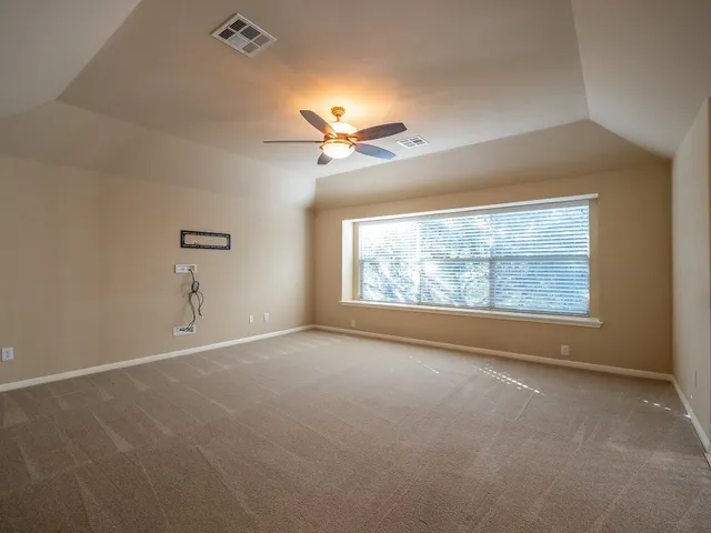 a view of a room with a ceiling fan and window
