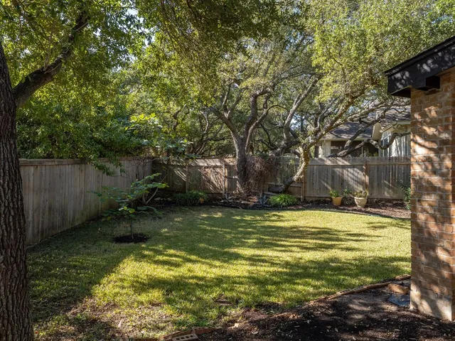 a view of a house with a large tree in the yard