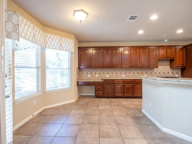 a kitchen with granite countertop a stove a sink and a microwave
