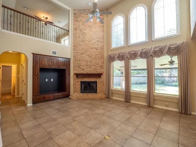 a view of an empty room with a fireplace and a window