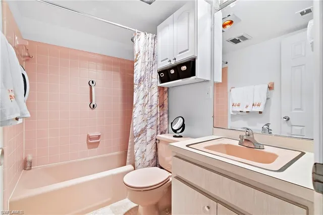 a bedroom with a bed a dresser and potted plant