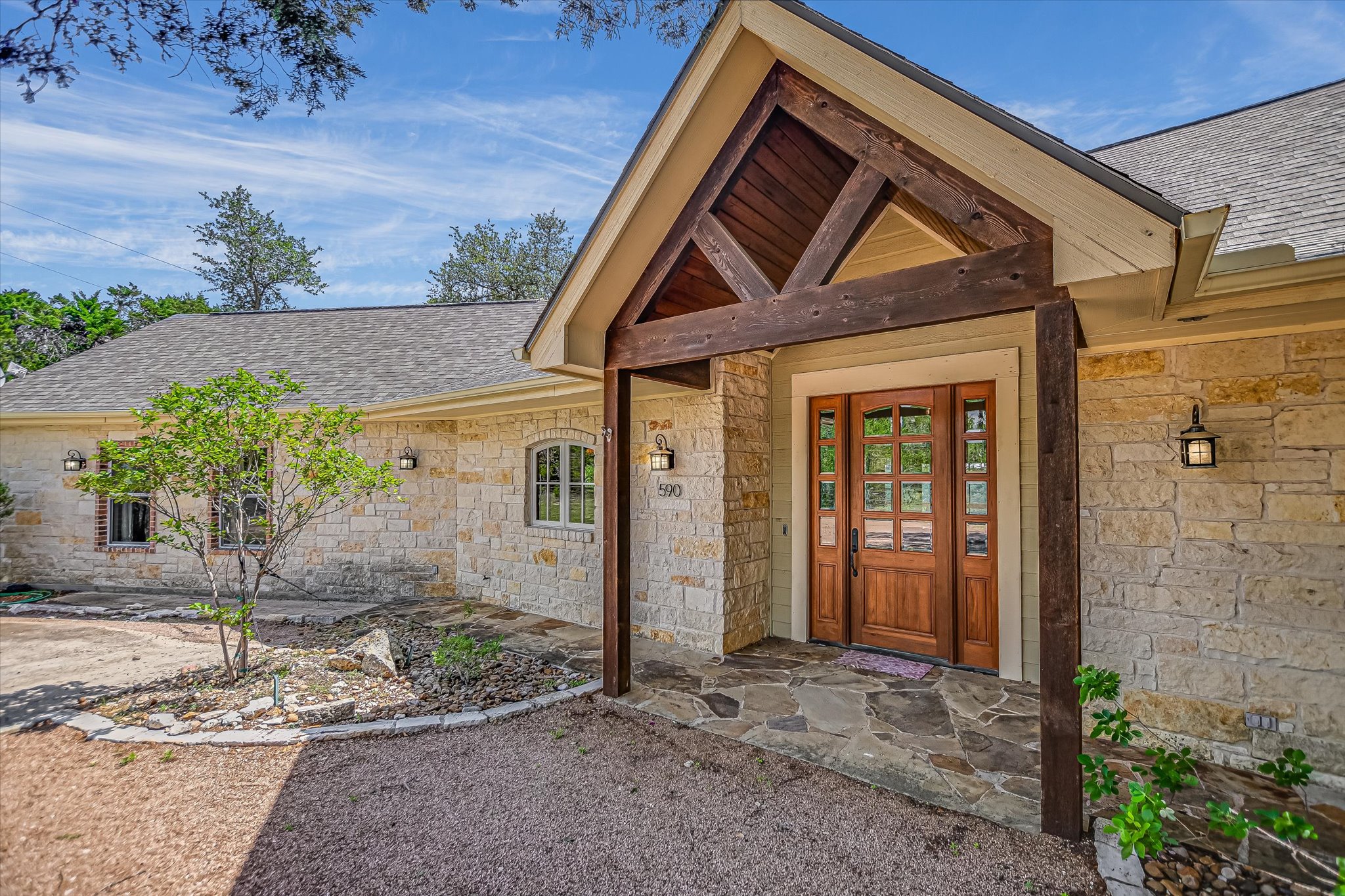 590 Rancho Grande Drive Wimberley, TX 78676 - Photo 4 of 30 a front view of a house with garden