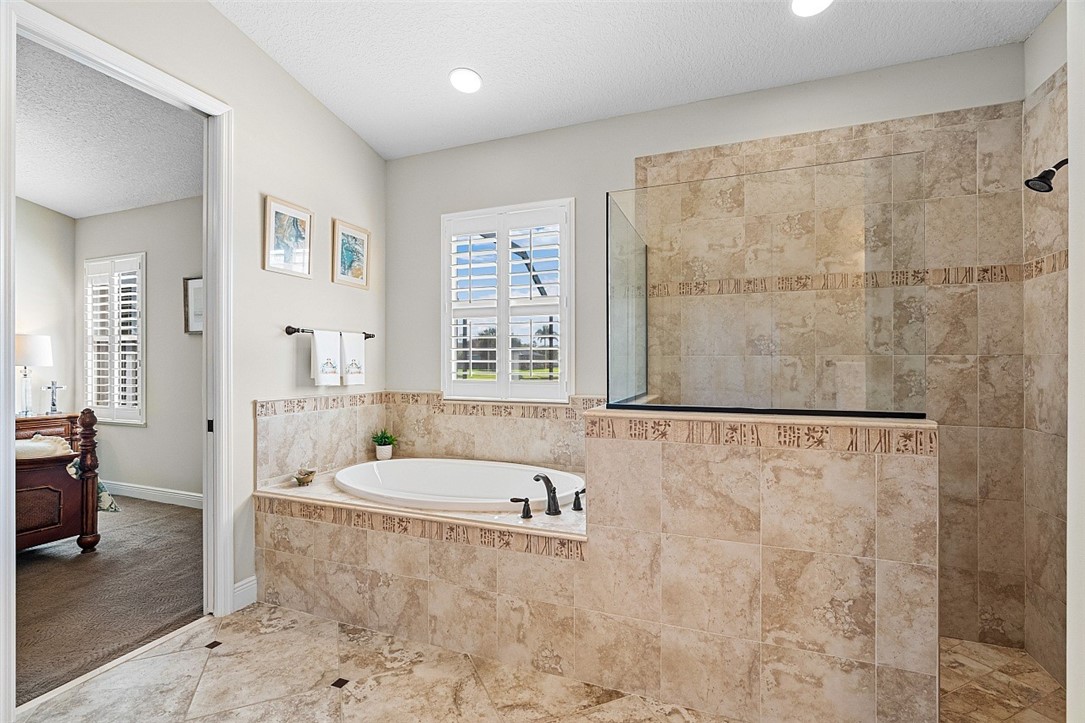 567 Gossamer Wing Way Sebastian, FL 32958 - Photo 11 of 35 a bathroom with a tub a window and a shower