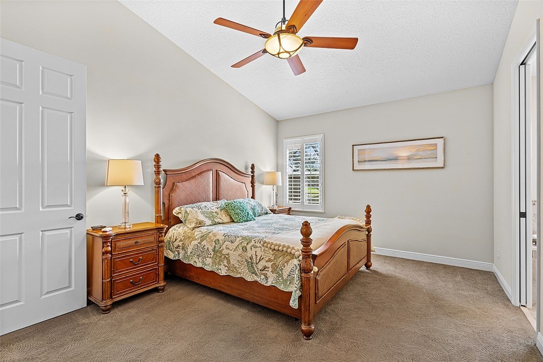 567 Gossamer Wing Way Sebastian, FL 32958 - Photo 12 of 35 a bedroom with a bed and a chandelier