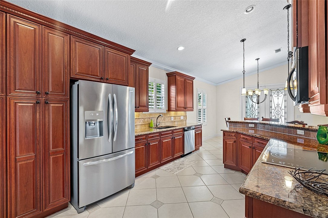 567 Gossamer Wing Way Sebastian, FL 32958 - Photo 8 of 35 a kitchen with granite countertop stainless steel appliances and wooden cabinets