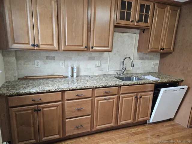 a kitchen with granite countertop white cabinets and stainless steel appliances