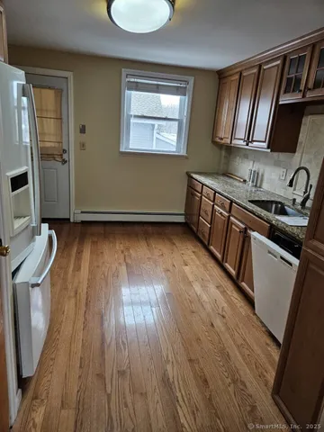 a kitchen with granite countertop wooden floors a stove and a sink