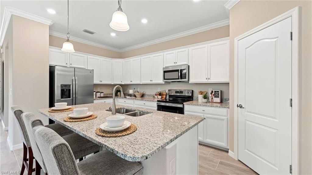 17262 Silverling Court Alva, FL 33920 - Photo 11 of 20 a kitchen with stainless steel appliances granite countertop a table chairs microwave and cabinets