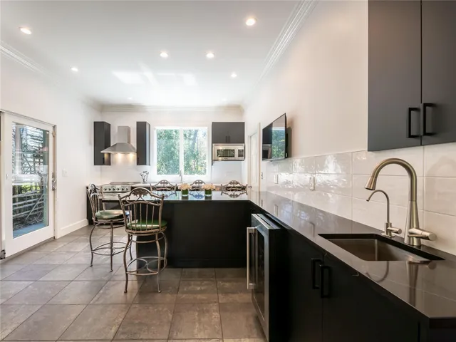 a kitchen with a sink and chairs
