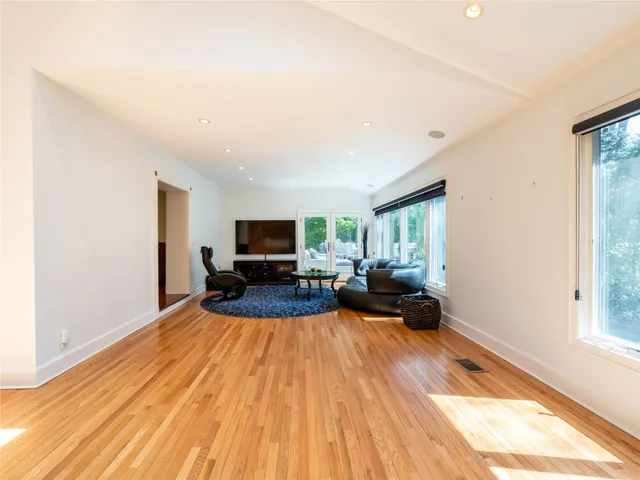 a living room with furniture a flat screen tv and a large window