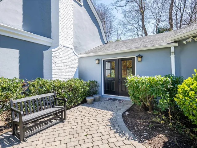 a view of a house with wooden fence and potted plants