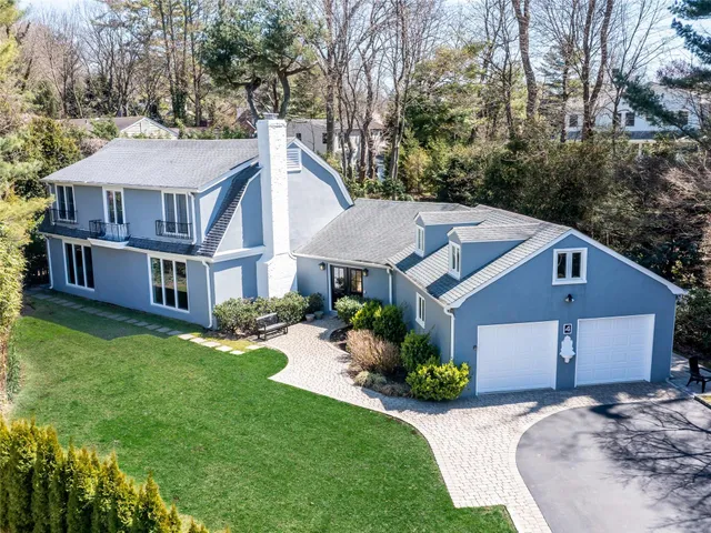 a aerial view of a house next to a big yard and large trees