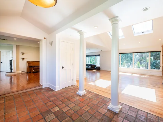 a view of a hallway view with wooden floor and a living room