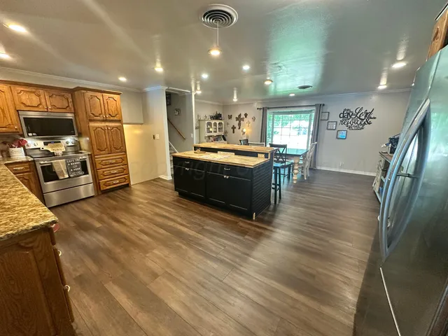a large white kitchen with wooden floor and a sink