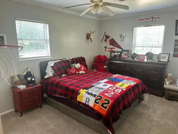 a bedroom with a bed and a chandelier fan