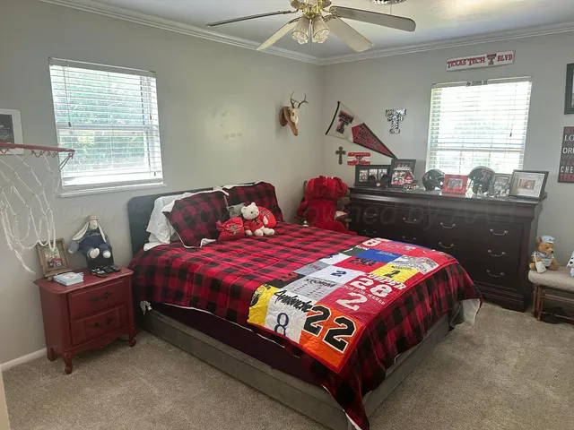 a bedroom with a bed and a chandelier fan