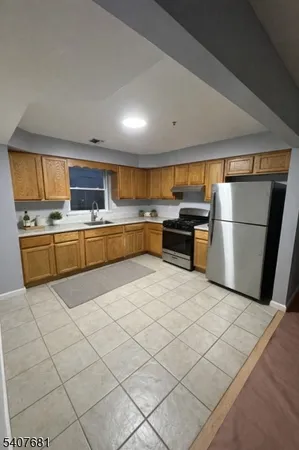 a large kitchen with a stove a refrigerator and a sink
