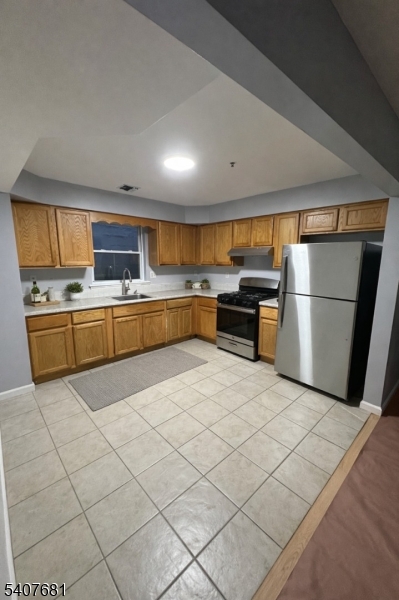 28 Branford Street Newark, NJ 07114 - Photo 14 of 15 a large kitchen with a stove a refrigerator and a sink
