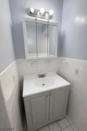 a utility room with a sink a vanity and mirror