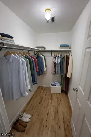 a view of walk in closet with clothes and shoes