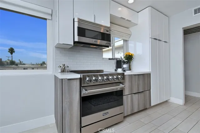 a kitchen with stainless steel appliances granite countertop a sink a stove and a wooden floors