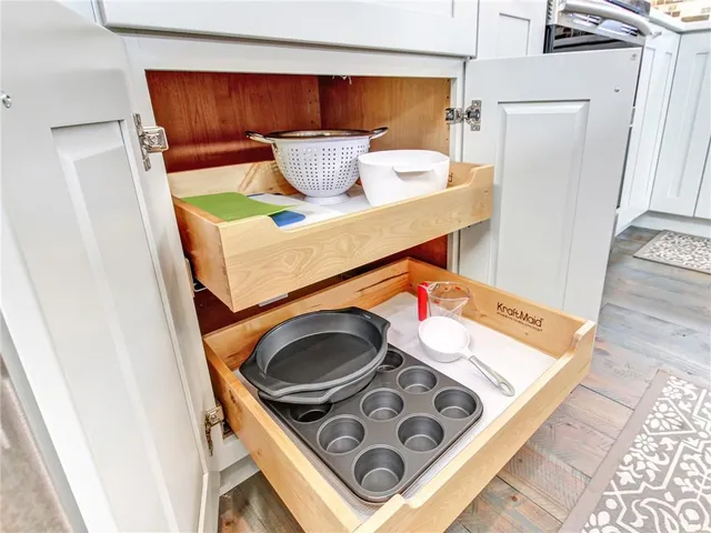 a kitchen with a stove and a wooden floor