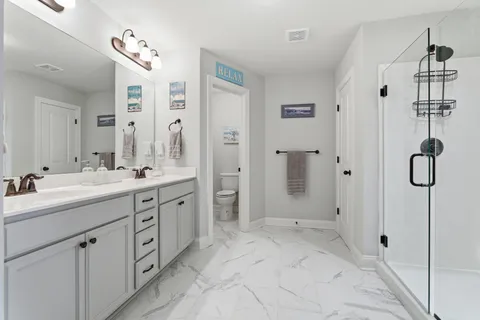 a spacious bathroom with a shower sink and mirror
