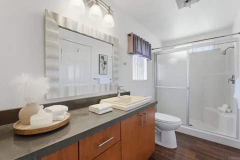a bathroom with a granite countertop sink toilet and shower