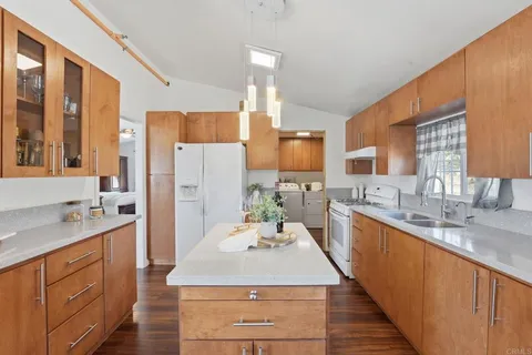 a large kitchen with stainless steel appliances kitchen island granite countertop a sink stove and refrigerator