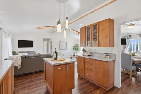 a kitchen with a sink stove and wooden floor